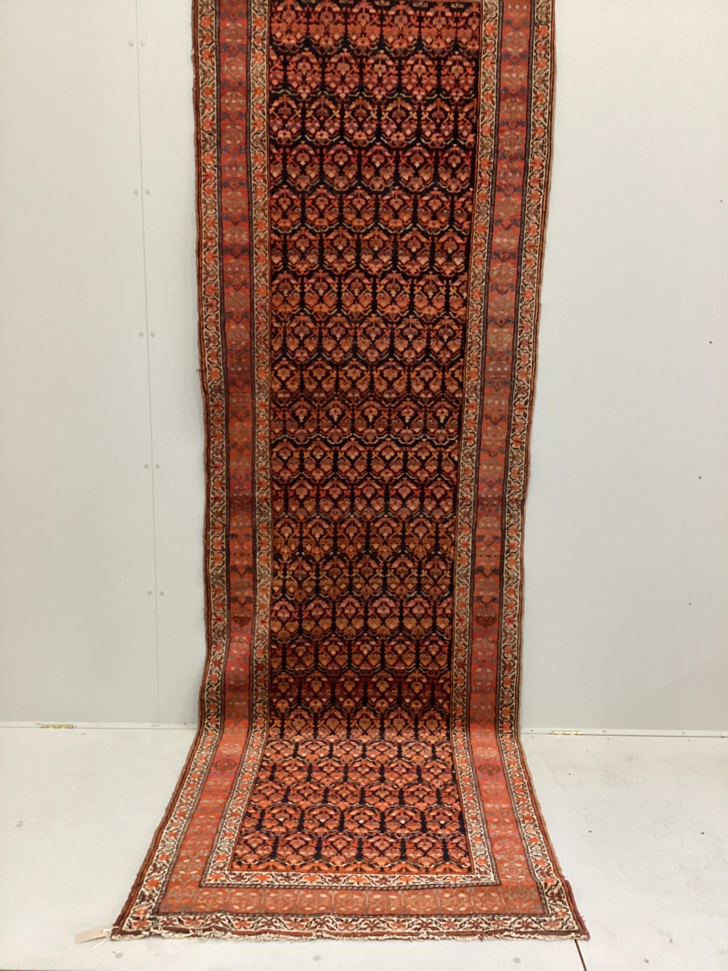 An Afshar blue ground runner woven with rows of floral devices, 354cm x 107cm. Condition - fair to good